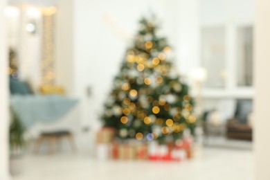 Photo of Blurred view of decorated Christmas tree and gift boxes in living room. Interior design