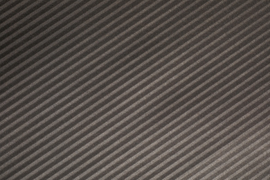 Dark grey corrugated sheet of cardboard as background, closeup