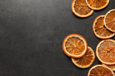 Photo of Dry orange slices on black table, flat lay. Space for text