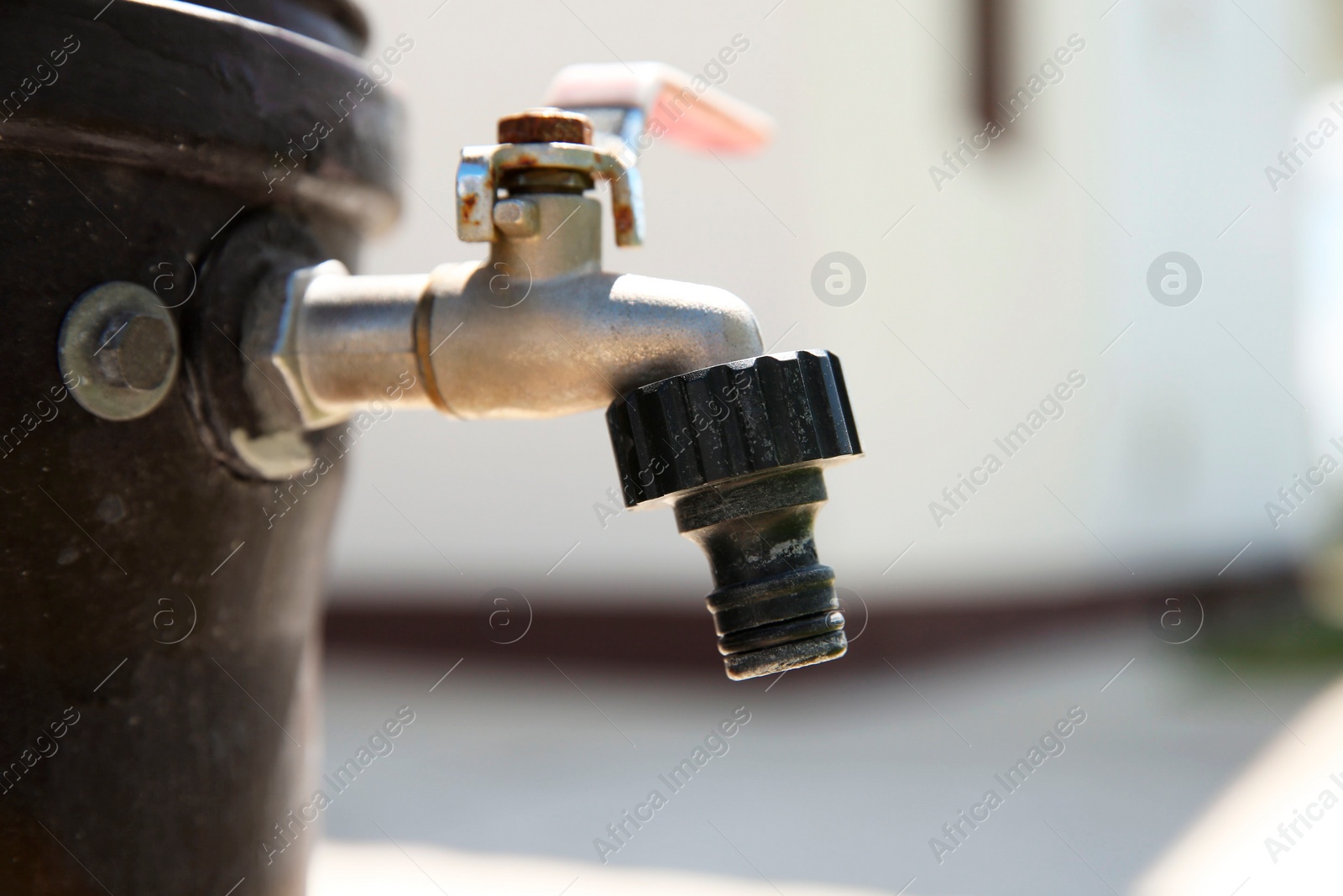 Photo of Metal water tap outdoors, closeup. Space for text