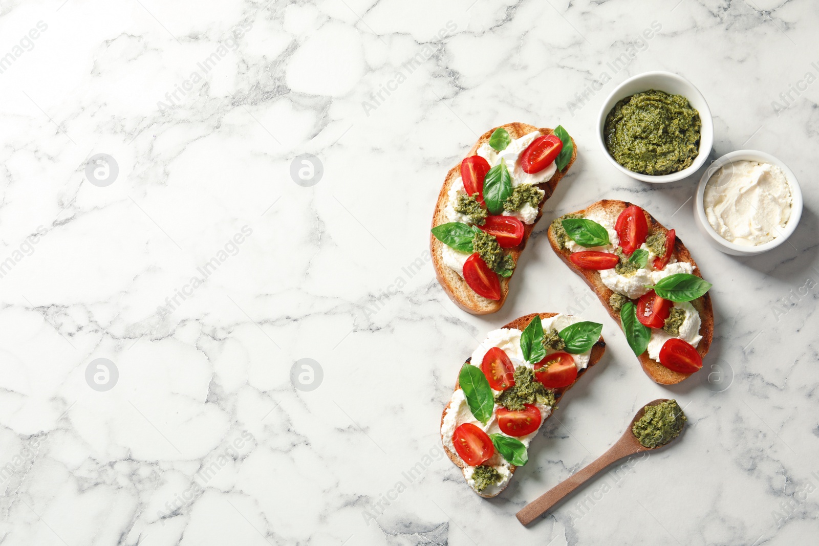 Photo of Toasted bread with tasty cream cheese and tomatoes on marble table, flat lay. Space for text