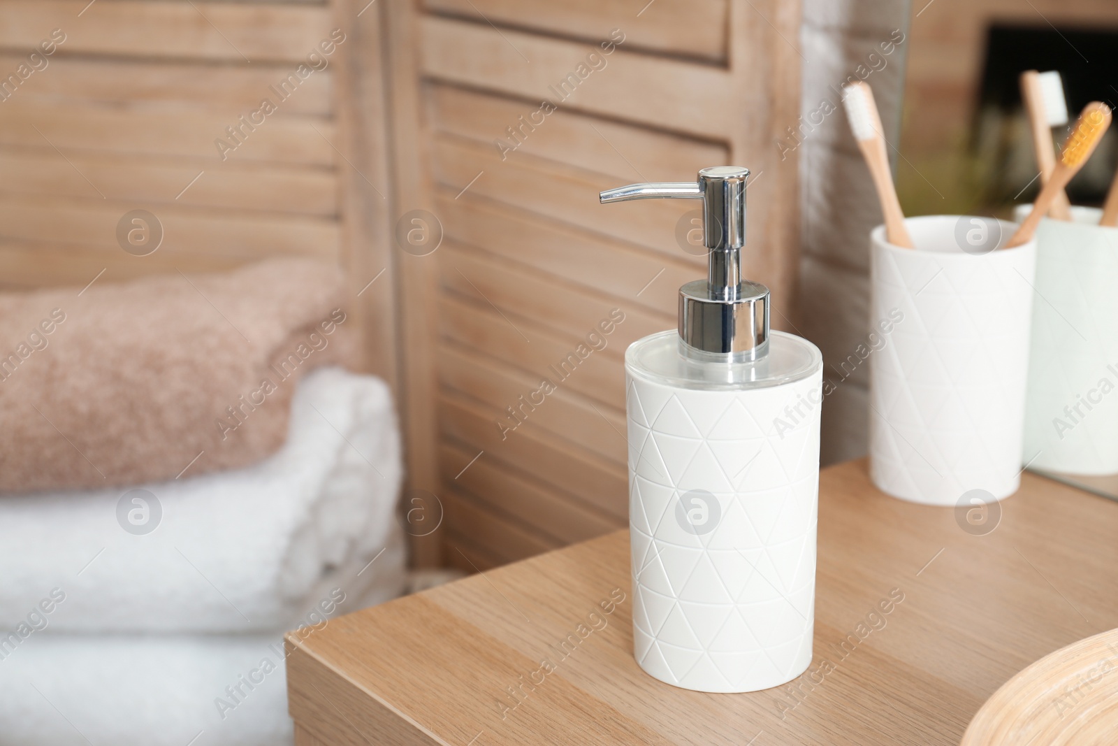 Photo of Bottle with liquid soap on table in bathroom. Space for text