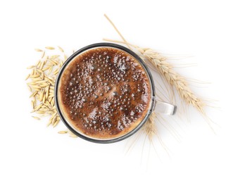 Cup of barley coffee, grains and spikes isolated on white, top view