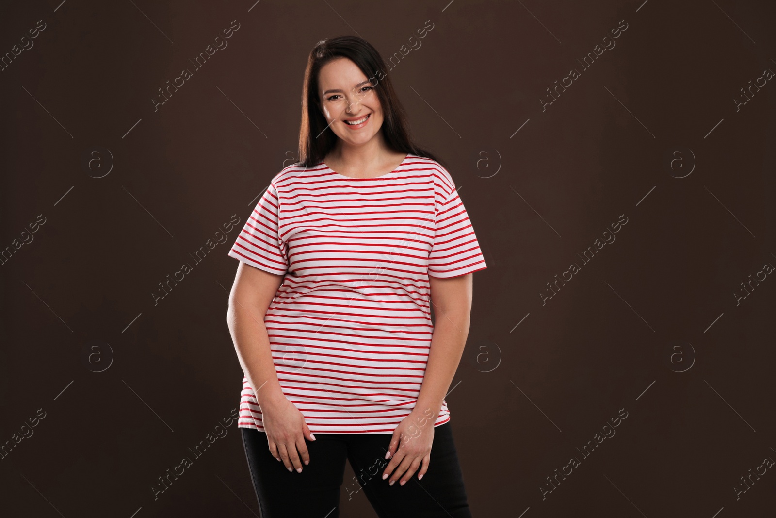 Photo of Beautiful overweight woman with charming smile on brown background