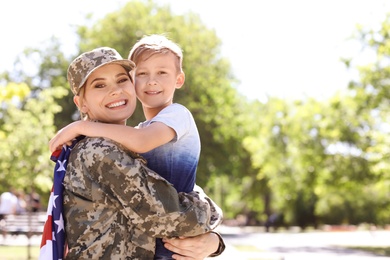 Photo of American soldier with her son outdoors. Military service