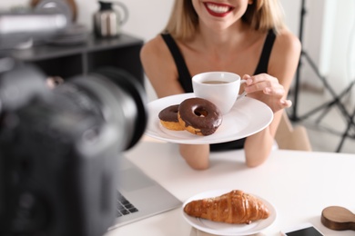 Food blogger recording video on camera at home