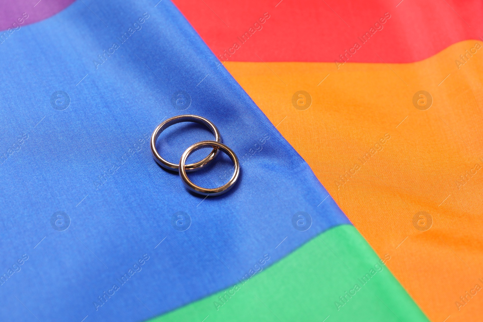 Photo of Wedding rings on rainbow LGBT flag, closeup