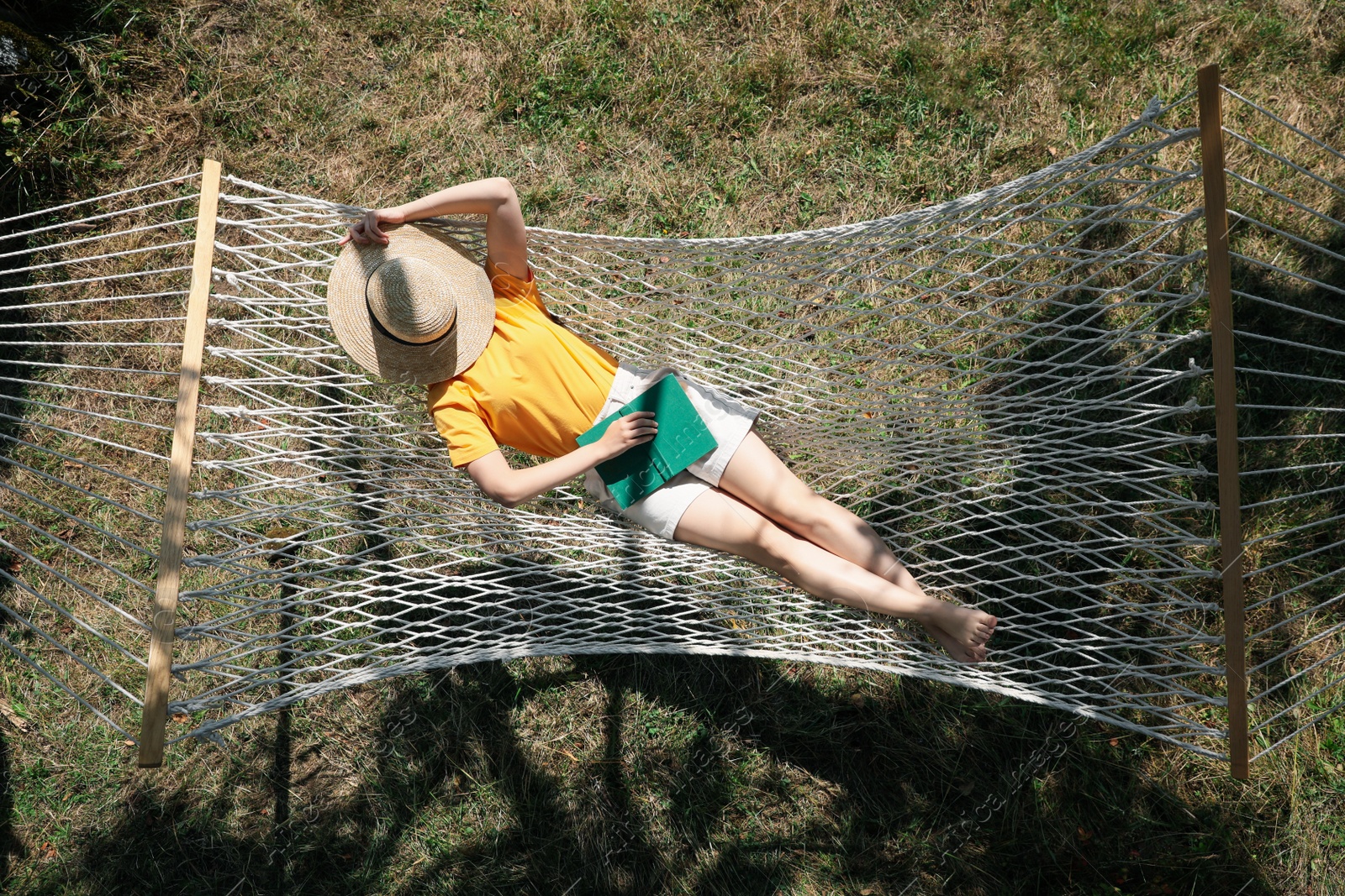 Photo of Young woman resting in hammock outdoors on sunny day, above view