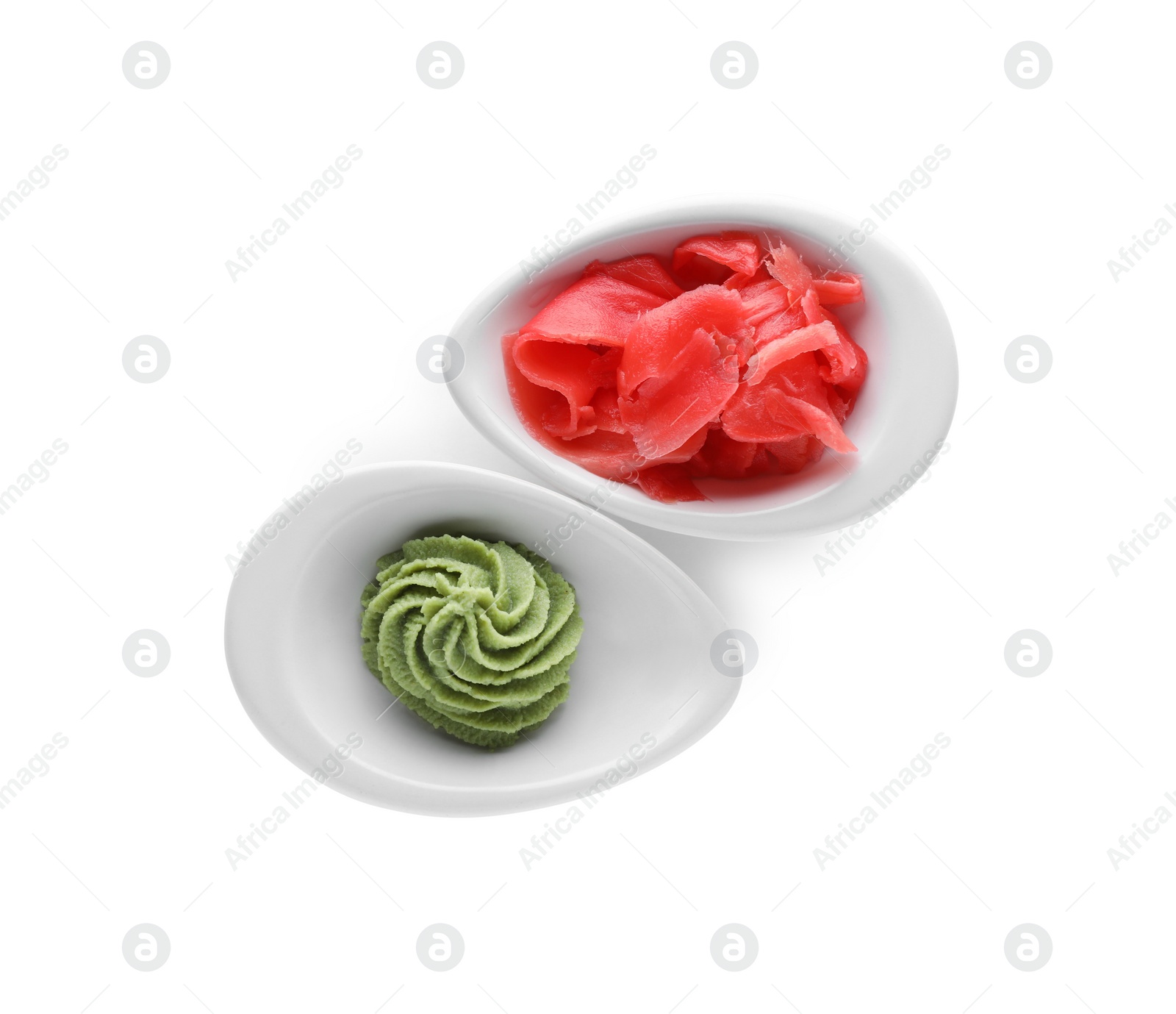 Photo of Bowls with swirl of wasabi paste and pickled ginger on white background, top view