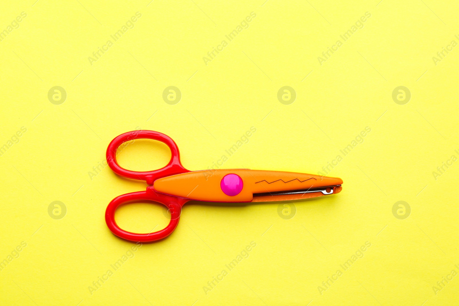 Photo of Decorative edge scissors on color background, top view