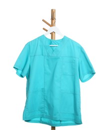 Photo of One turquoise medical uniform on rack against white background