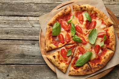 Photo of Delicious Margherita pizza on wooden table, top view. Space for text