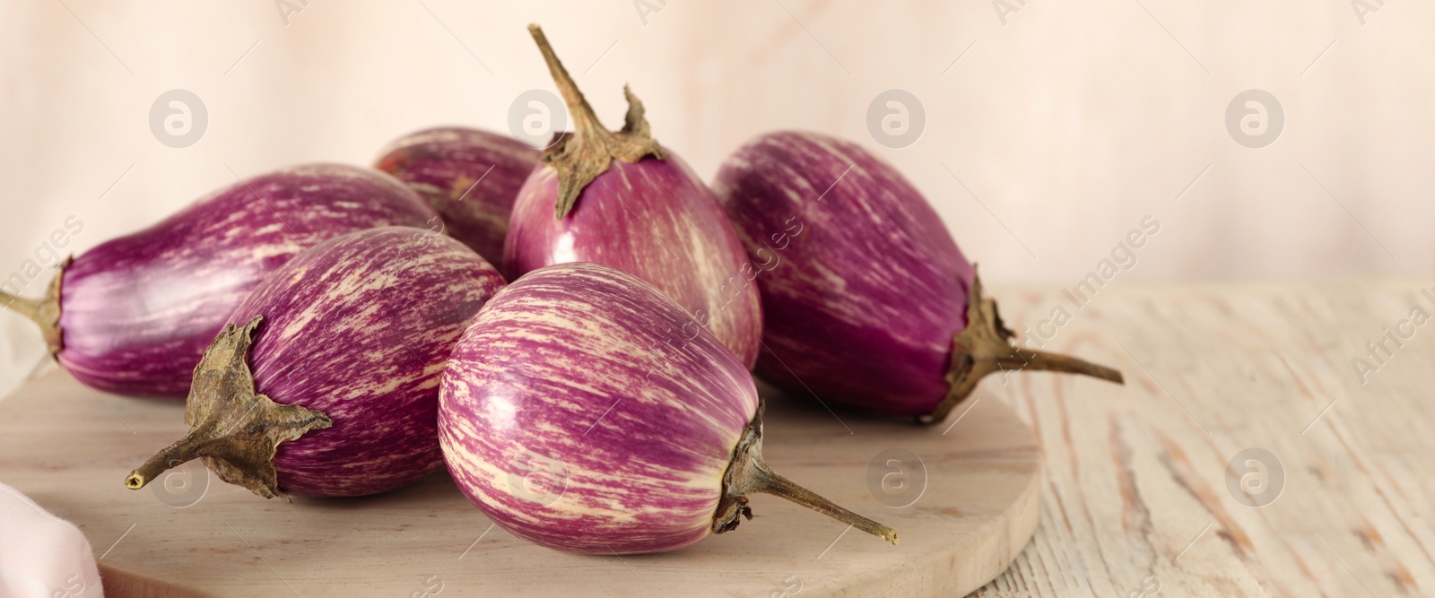 Image of Ripe purple eggplants on white wooden table, closeup. Banner design