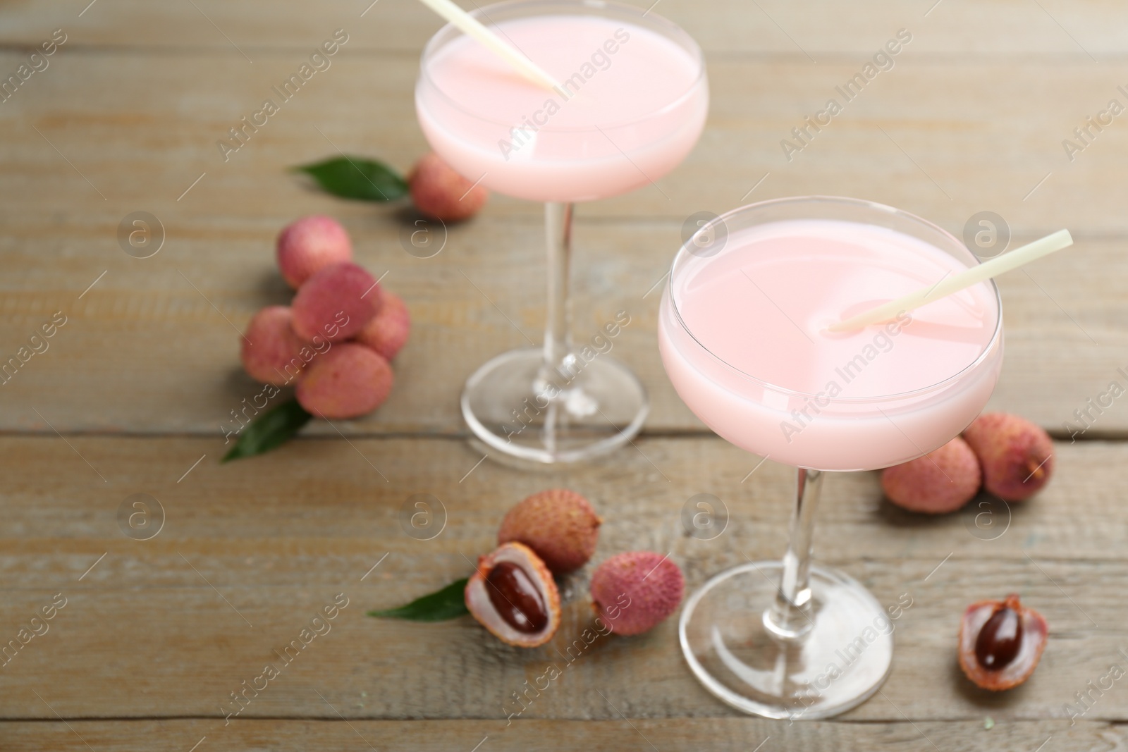Photo of Delicious lychee cocktails and fresh fruits on wooden table. Space for text