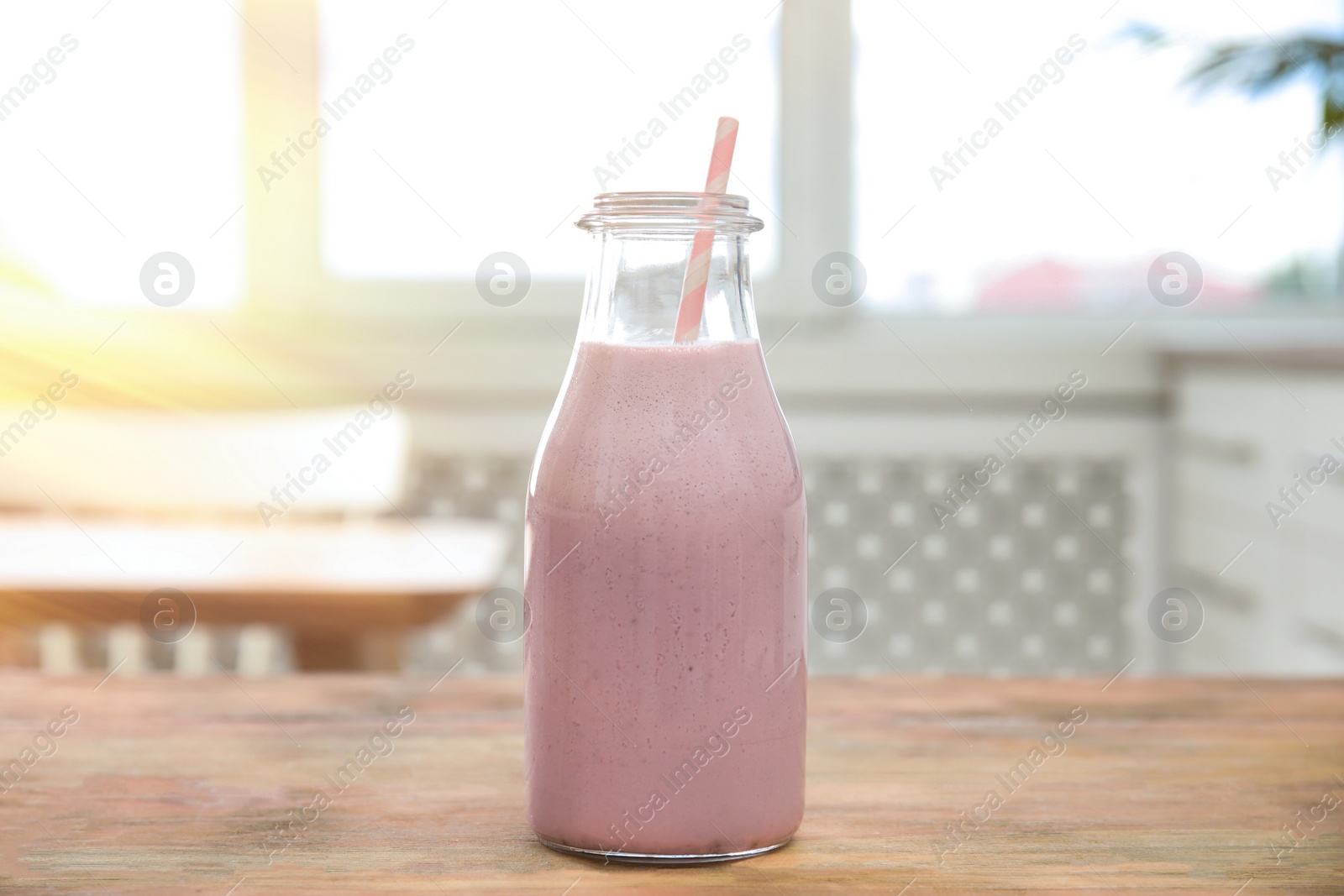 Photo of Tasty fresh milk shake on wooden table indoors