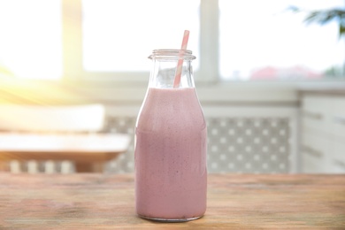 Photo of Tasty fresh milk shake on wooden table indoors