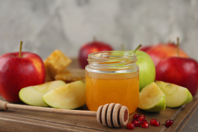 Photo of Honey, apples and pomegranate on wooden board, closeup. Rosh Hashanah holiday