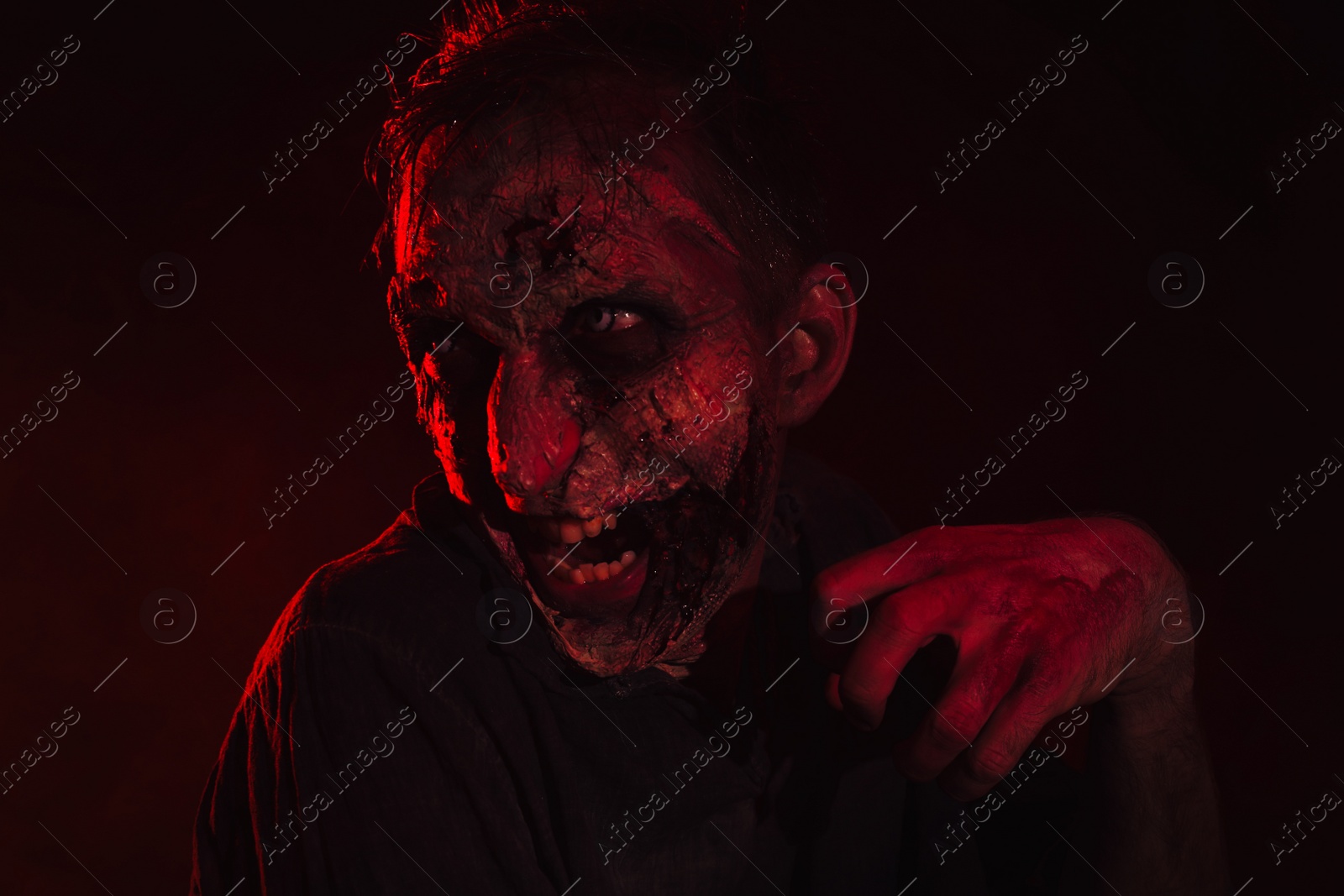 Photo of Scary zombie on dark background. Halloween monster