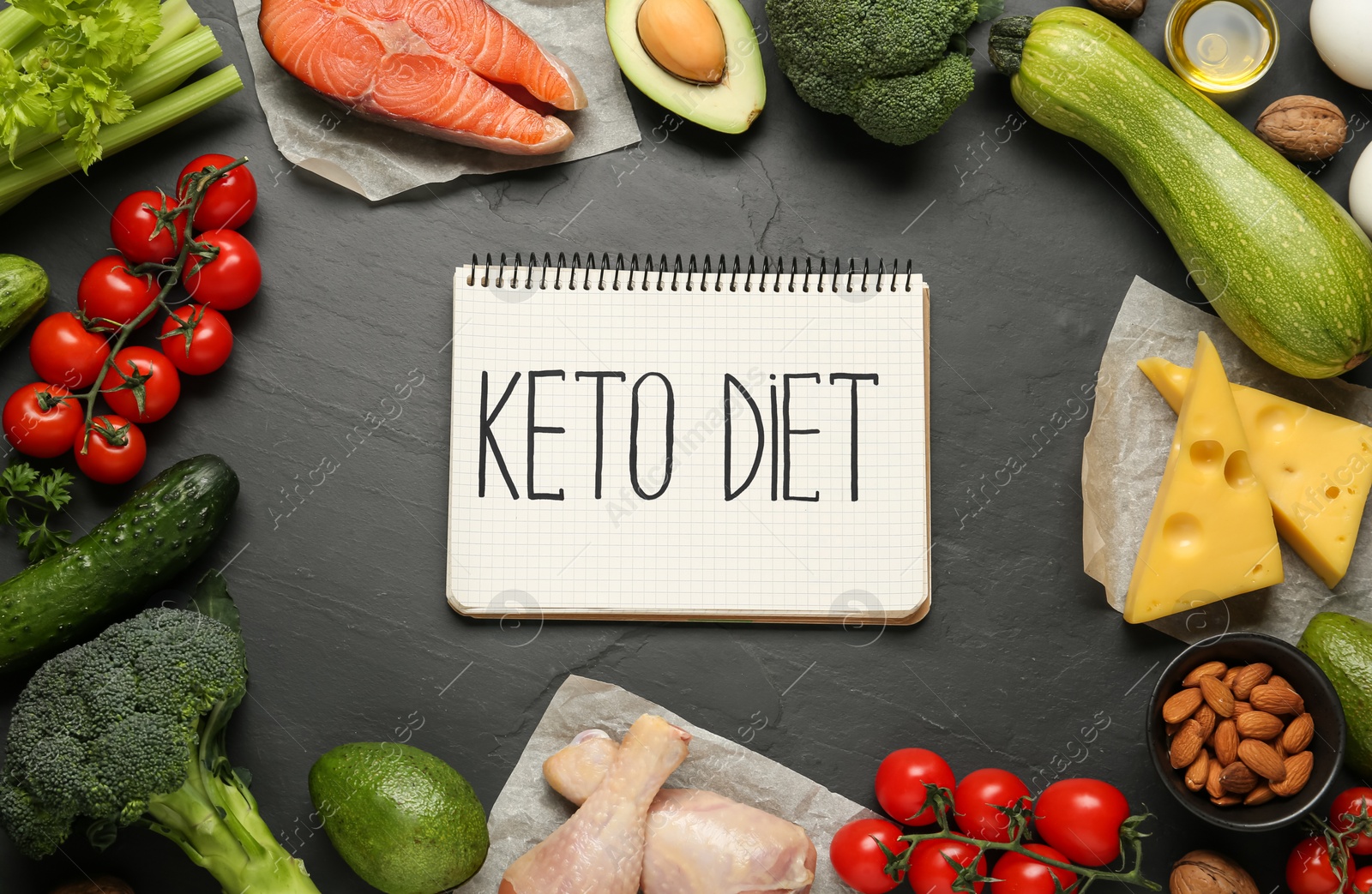 Photo of Notebook with words Keto Diet and fresh products on black table, flat lay