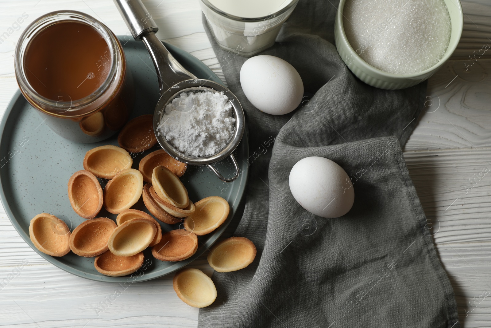 Photo of Ingredients for delicious walnut shaped cookies with condensed milk on white wooden table, flat lay