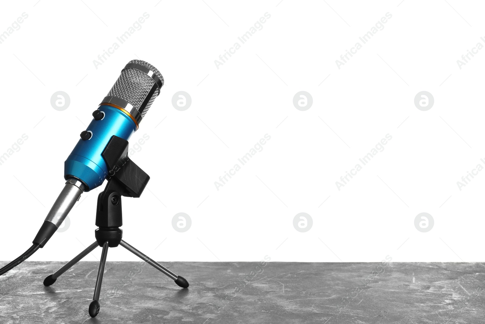 Photo of Microphone on table against white background. Space for text