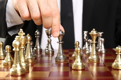 Photo of Man moving chess piece on board, closeup