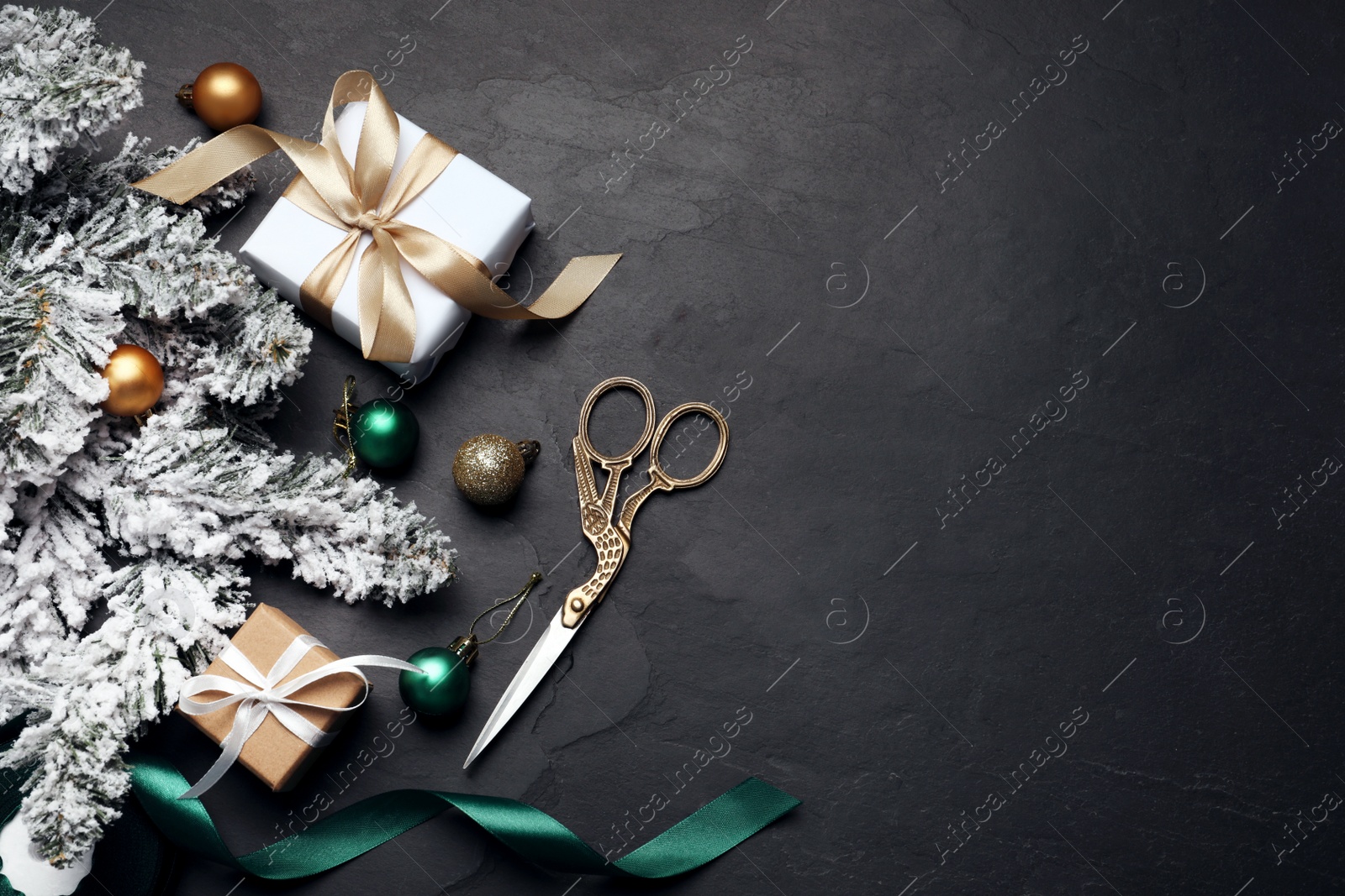 Photo of Flat lay composition with beautiful gift boxes Christmas decor on black table. Space for text