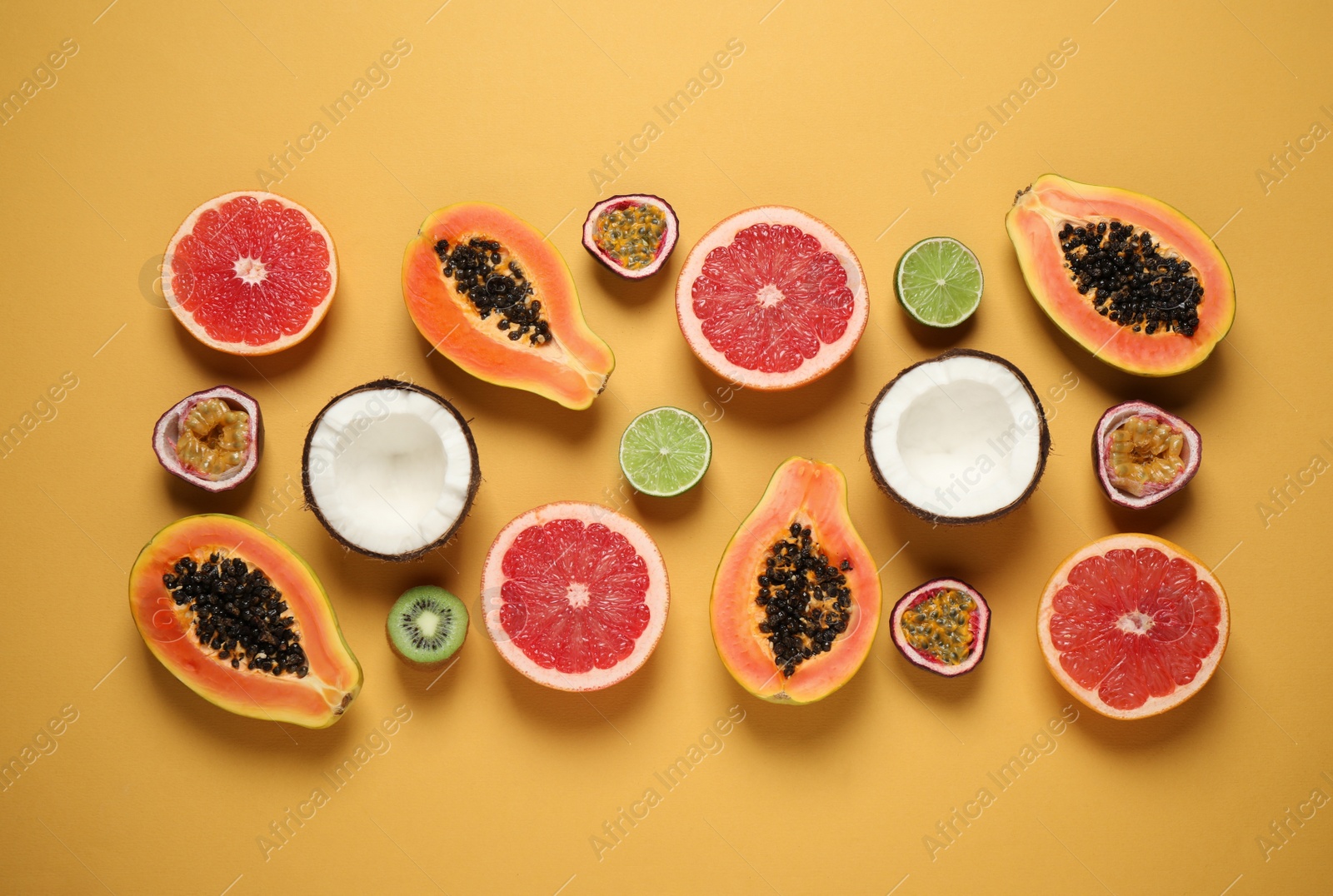 Photo of Fresh ripe papaya and other fruits on yellow background. flat lay