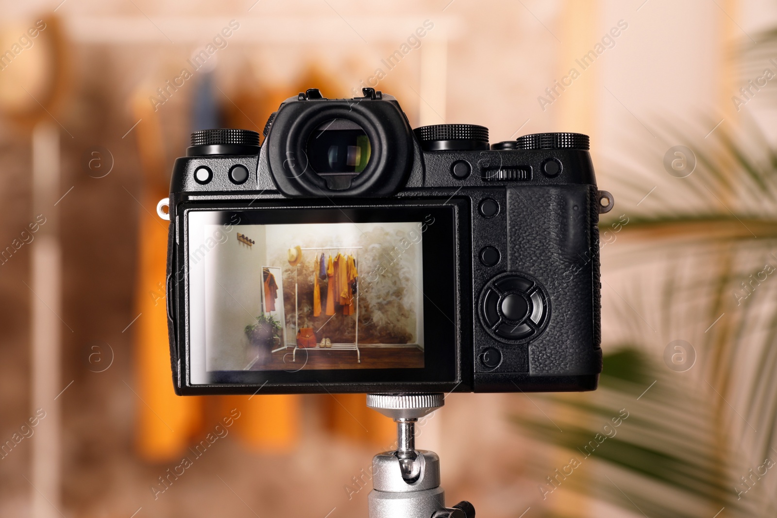 Photo of Taking photo of stylish clothes indoors, focus on camera