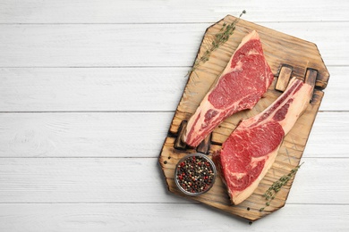 Photo of Fresh raw beef meat and peppers mix on white wooden table, top view. Space for text