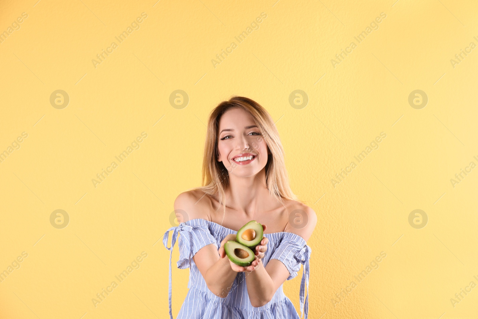 Photo of Portrait of young beautiful woman with ripe delicious avocado on color background