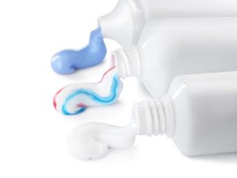 Photo of Tubes with toothpaste on white background. Dental care