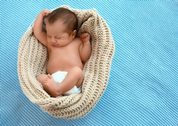 Photo of Cute little baby sleeping in cradle on light blue background, above view. Space for text