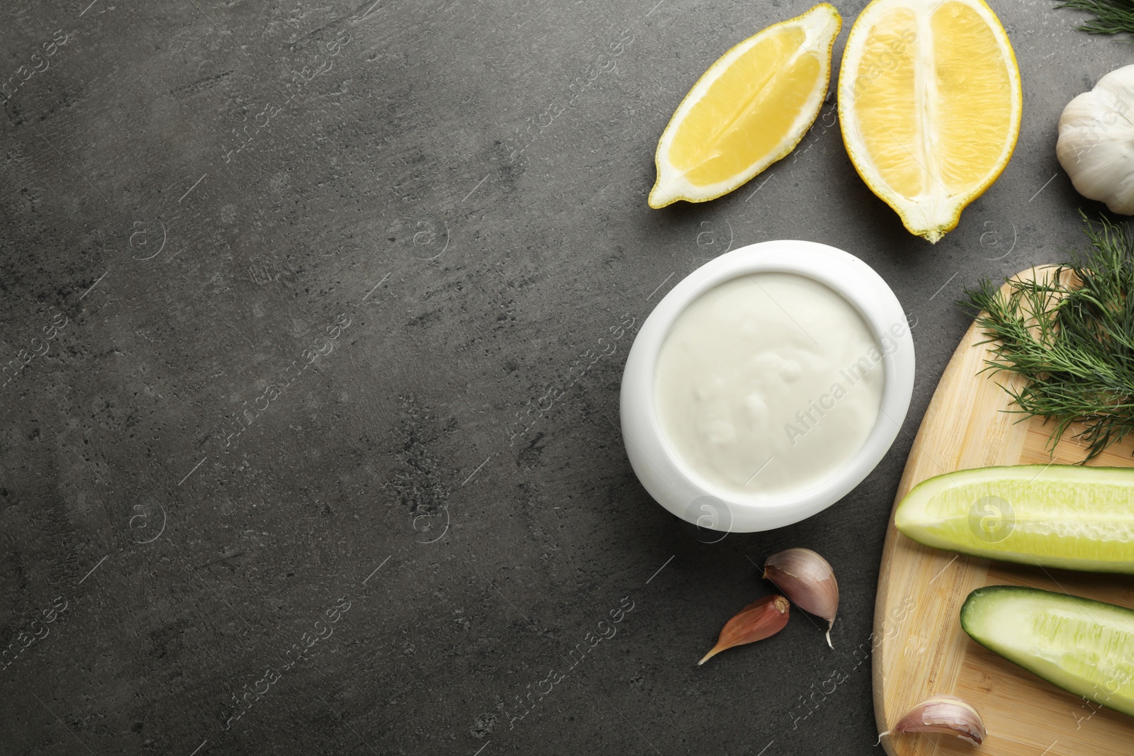 Photo of Flat lay composition with cucumber sauce and ingredients on grey background. Space for text