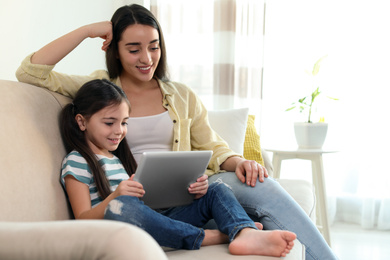 Photo of Mother and daughter reading E-book together at home