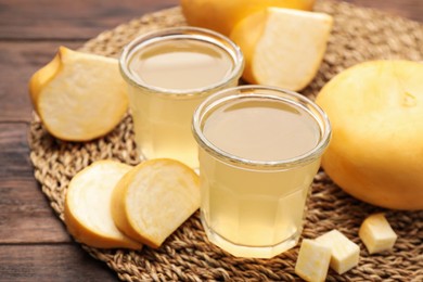 Photo of Glasses of freshly made turnip juice on wooden table