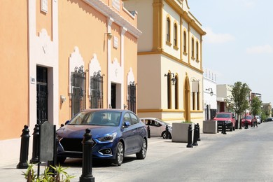 Beautiful view of city street with modern buildings and parked cars