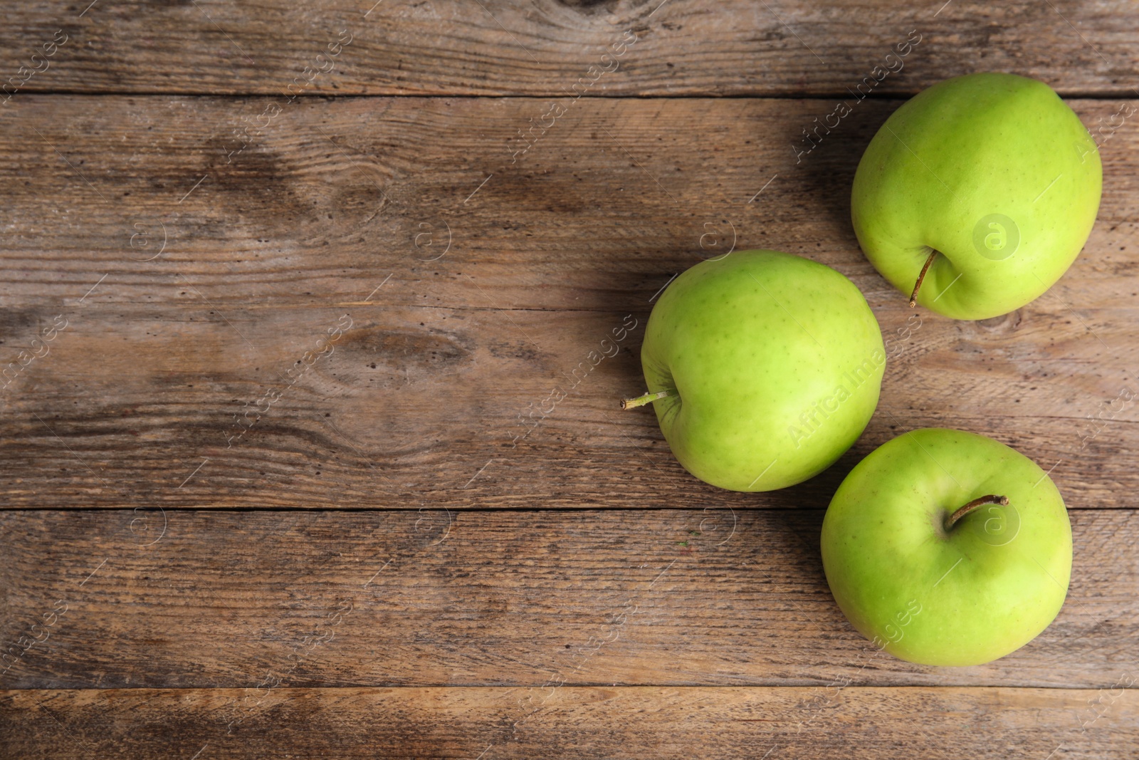 Photo of Flat lay composition of fresh ripe green apples on wooden table, space for text