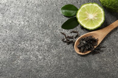 Photo of Dry bergamot tea leaves and fresh fruit on grey table, flat lay. Space for text