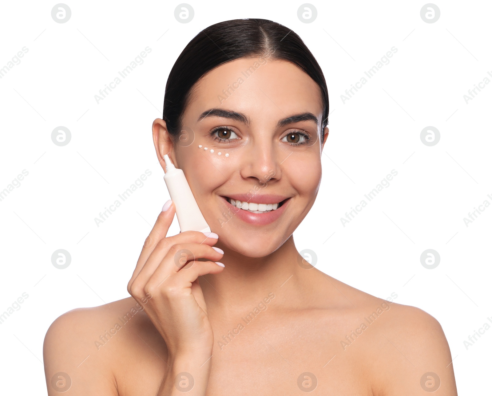 Photo of Beautiful young woman with cream on skin under eye against white background