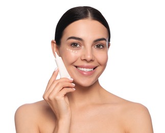 Photo of Beautiful young woman with cream on skin under eye against white background