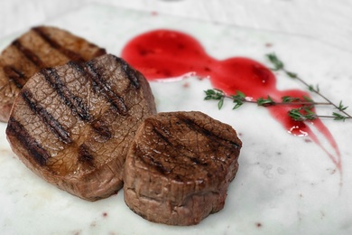 Grilled meat with sauce and thyme on light background, closeup