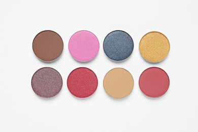 Different beautiful eye shadows on white background, flat lay