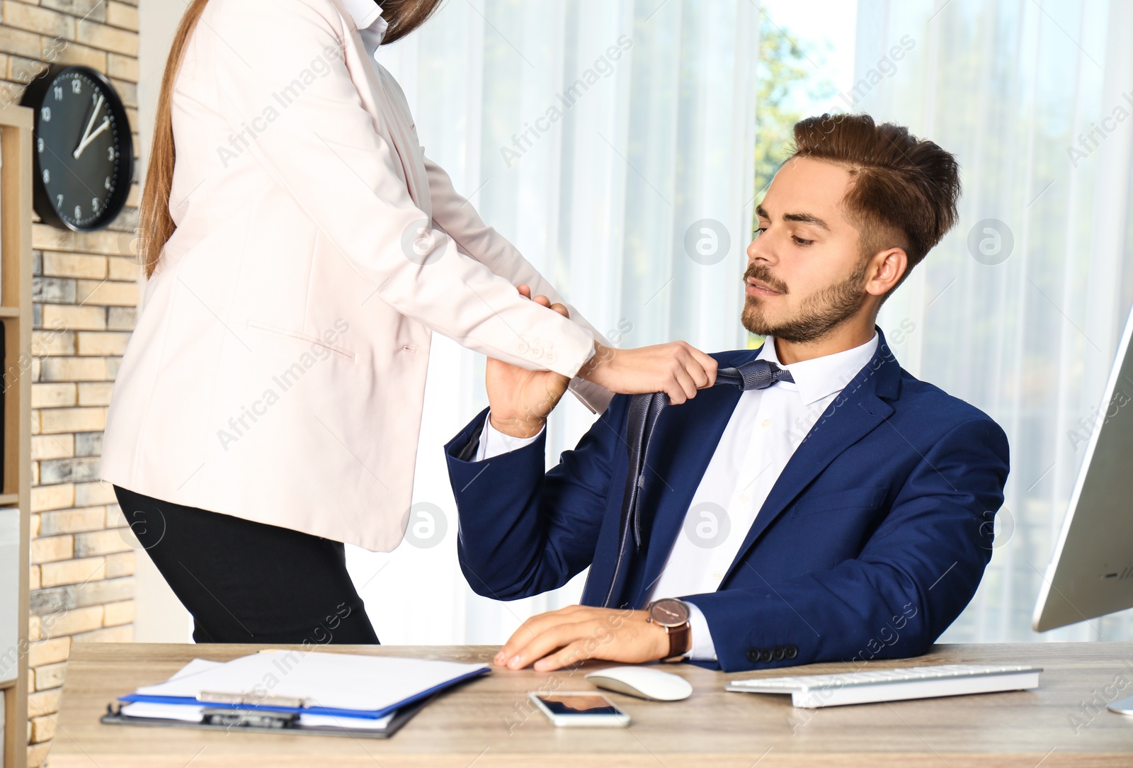 Photo of Woman molesting her male colleague in office. Sexual harassment at work