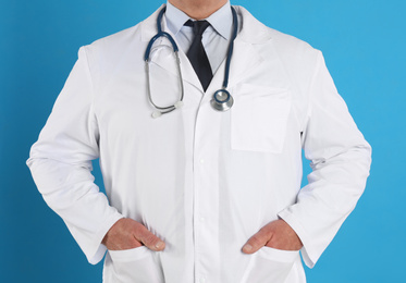 Senior doctor with stethoscope on blue background, closeup