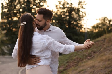Photo of Lovely couple dancing together outdoors. Romantic date