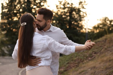 Lovely couple dancing together outdoors. Romantic date