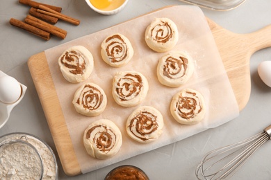 Photo of Flat lay composition with raw cinnamon rolls on grey background