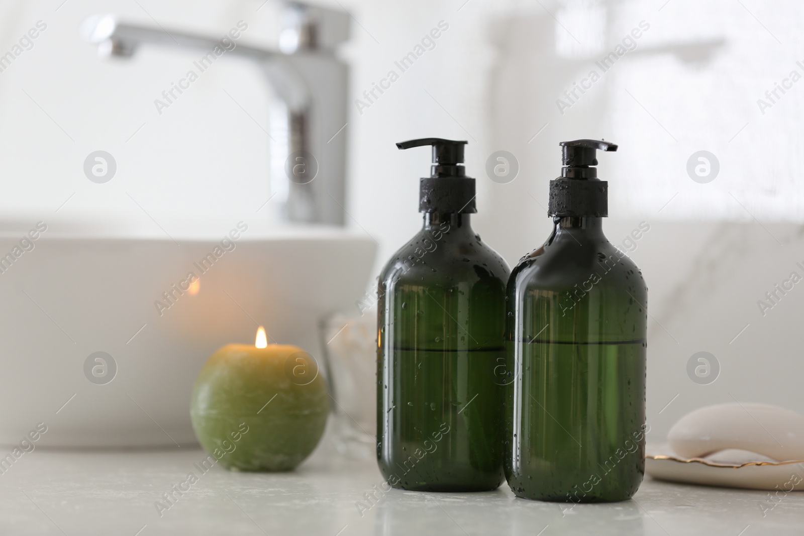 Photo of Green soap dispensers on countertop near sink in bathroom. Space for text