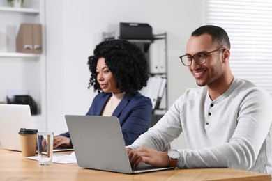 Young colleagues working together at table in office